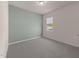Bright bedroom with a green accent wall, neutral carpet, and a window at 1401 Justice Union Ct, Raleigh, NC 27604