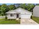 Charming single-Gathering home with gray siding, attached garage, and well-manicured front lawn and landscaping at 1401 Justice Union Ct, Raleigh, NC 27604