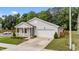 Well-maintained one story home with gray siding, a front porch, an attached garage, and manicured landscaping at 1401 Justice Union Ct, Raleigh, NC 27604