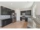 Modern kitchen featuring dark cabinets, stainless steel appliances, granite countertops, and stylish backsplash at 1534 Glenwater Dr, Cary, NC 27519