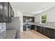 Stylish kitchen featuring stainless steel appliances, dark cabinetry, granite countertops, and a tiled backsplash at 1534 Glenwater Dr, Cary, NC 27519