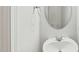 Neat powder room featuring a pedestal sink, oval mirror, and fresh, white walls at 1534 Glenwater Dr, Cary, NC 27519