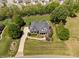 Stunning aerial view of a traditional home with a lush green lawn, mature trees, and a long driveway at 154 Sicily Dr, Clayton, NC 27527