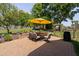 Stone patio with seating under umbrella, surrounded by manicured landscaping at 154 Sicily Dr, Clayton, NC 27527