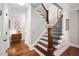 Elegant staircase with wood and black iron railing, white risers, and hardwood floors at 154 Sicily Dr, Clayton, NC 27527
