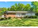 Charming single-story home featuring a brick and white facade with a well-maintained lawn and mature trees at 1593 E Washington Ave, Creedmoor, NC 27522