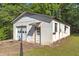 White cinder block garage with two doors and a single door, with lush grass at 1593 E Washington Ave, Creedmoor, NC 27522