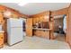 Efficient kitchen with wood cabinetry, white appliances, and an open layout at 1593 E Washington Ave, Creedmoor, NC 27522