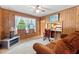Inviting living room with wood paneling, ceiling fan, and comfortable seating area at 1593 E Washington Ave, Creedmoor, NC 27522
