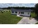 Aerial view showcasing the white brick home with red front door, driveway, and surrounding lawn at 1676 Richardson Bass Rd, Kenly, NC 27542