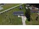 Aerial view displaying the house, detached garage, grassy yard, and other houses in the distance at 1676 Richardson Bass Rd, Kenly, NC 27542