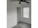 Bright bedroom features a ceiling fan, built-in closet shelving and sleek, gray laminate flooring at 1676 Richardson Bass Rd, Kenly, NC 27542