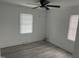 Sunlit bedroom with two windows, light gray flooring, and a ceiling fan at 1676 Richardson Bass Rd, Kenly, NC 27542