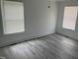 Large bedroom with modern gray floors, lots of natural light and crisp, white trim at 1676 Richardson Bass Rd, Kenly, NC 27542
