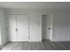 Bright bedroom featuring modern gray flooring, white walls, and a double door closet at 1676 Richardson Bass Rd, Kenly, NC 27542