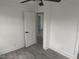 Bedroom with gray floors, white door, ceiling fan, and white trim at 1676 Richardson Bass Rd, Kenly, NC 27542