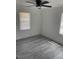Bedroom features two windows, a ceiling fan, and light gray flooring at 1676 Richardson Bass Rd, Kenly, NC 27542
