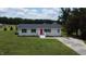 Aerial view of single-story home with red front door, white exterior, black shutters, and a spacious green yard at 1676 Richardson Bass Rd, Kenly, NC 27542