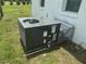 A modern Goodman brand HVAC unit sitting on the green grass beside the white brick home at 1676 Richardson Bass Rd, Kenly, NC 27542