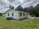 Charming one-story brick home with a landscaped yard, black shutters, and a red front door at 1676 Richardson Bass Rd, Kenly, NC 27542