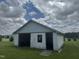 Large white-bricked open garage space featuring a window and concrete flooring in a spacious yard at 1676 Richardson Bass Rd, Kenly, NC 27542