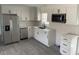 Modern kitchen featuring sleek white cabinetry, stainless steel appliances, quartz countertops, and subway tile backsplash at 1676 Richardson Bass Rd, Kenly, NC 27542