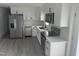 Well-equipped kitchen with white cabinets, stainless steel appliances, a black faucet, and stylish gray wood-look flooring at 1676 Richardson Bass Rd, Kenly, NC 27542