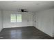 Elegant living room with gray wood-look floors, decorative wall paneling, and a ceiling fan for added comfort at 1676 Richardson Bass Rd, Kenly, NC 27542