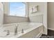 Bright bathroom showcasing a soaking tub with chrome fixtures and a large window at 169 Horseshoe Pl # 55, Angier, NC 27501