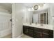 Bright bathroom featuring a double sink vanity, large mirror, and a shower and tub combination at 1716 Longmont Dr, Wake Forest, NC 27587