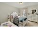 Cozy bedroom featuring a bed with colorful bedding and decorative furniture, illuminated by a window at 1716 Longmont Dr, Wake Forest, NC 27587