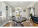 Cozy dining room features an elegant chandelier, hardwood flooring, and see-through chairs at 1716 Longmont Dr, Wake Forest, NC 27587