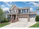 Charming two-story home featuring brick and siding, a covered porch, a two-car garage, and landscaped front yard at 1716 Longmont Dr, Wake Forest, NC 27587