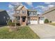 Charming two-story home with brick and siding, a well-manicured lawn, and a three-car garage at 1716 Longmont Dr, Wake Forest, NC 27587