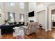 Bright living room with a cozy fireplace, hardwood floors, blue sofas, a loft and large windows at 1716 Longmont Dr, Wake Forest, NC 27587