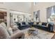 Bright and airy living room featuring high ceilings, hardwood floors, blue sofas and large windows at 1716 Longmont Dr, Wake Forest, NC 27587