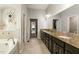Bathroom featuring a double vanity with granite countertops, a soaking tub, and neutral-colored tiling at 1716 Longmont Dr, Wake Forest, NC 27587