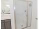 Bathroom featuring a glass-enclosed shower, gray vanity, and framed mirror at 176 Lowery Ln, Benson, NC 27504
