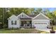 Charming single-story home featuring a well-manicured lawn, gray siding, and a two-car garage in a peaceful, wooded setting at 176 Lowery Ln, Benson, NC 27504