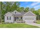 Charming home featuring stone accents, a well-manicured lawn, and an attached two-car garage at 176 Lowery Ln, Benson, NC 27504