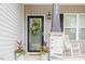 Inviting entrance featuring a decorative wreath, stone pillar, and potted plants at 176 Lowery Ln, Benson, NC 27504