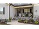 Inviting front porch with rocking chairs, decorative plants, stone accents, and a well-maintained walkway at 176 Lowery Ln, Benson, NC 27504