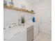 Bright laundry room with white washer and dryer, gray cabinets and marble tile flooring at 176 Lowery Ln, Benson, NC 27504