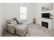 Cozy living room area with fireplace, comfy chair, ottoman, and bright natural light at 176 Lowery Ln, Benson, NC 27504