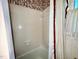 Bathroom bathtub and shower, featuring vintage white tile and red-accented window at 1818 Brookrun Rd, Henderson, NC 27536