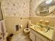 This bathroom features a vanity, toilet, and seashell themed wallpaper at 1818 Brookrun Rd, Henderson, NC 27536