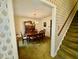 Dining room with hutch and carpeted floors, adjacent to a stairway and entryway at 1818 Brookrun Rd, Henderson, NC 27536