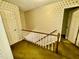 Carpeted hallway with a wooden banister and patterned wallpaper at 1818 Brookrun Rd, Henderson, NC 27536