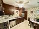 Kitchen with dark wood cabinets, stainless steel appliances, and vintage wallpaper, blending retro charm at 1818 Brookrun Rd, Henderson, NC 27536