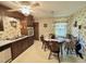 Eat-in kitchen featuring wood cabinets, vintage wallpaper, ceiling fan, and a dining table with chairs at 1818 Brookrun Rd, Henderson, NC 27536